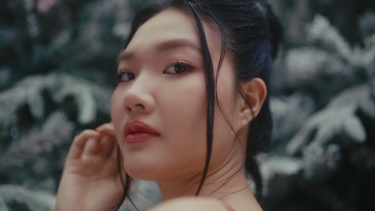 A serene woman gazes thoughtfully, framed by a winter forest setting, evoking calm