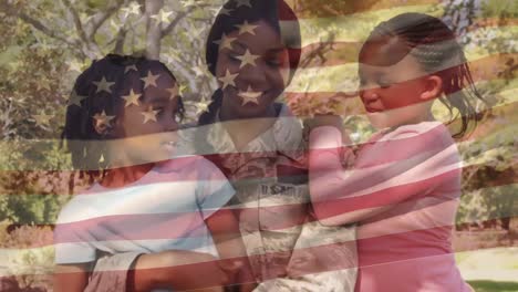 una madre en uniforme militar con hijas en el parque