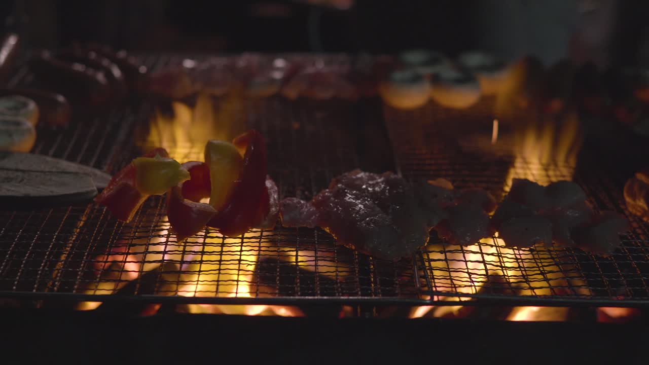 Primo piano su funghi, salsicce, pollo e melanzane che grigliano sul barbecue davanti alla casa in un giardino.