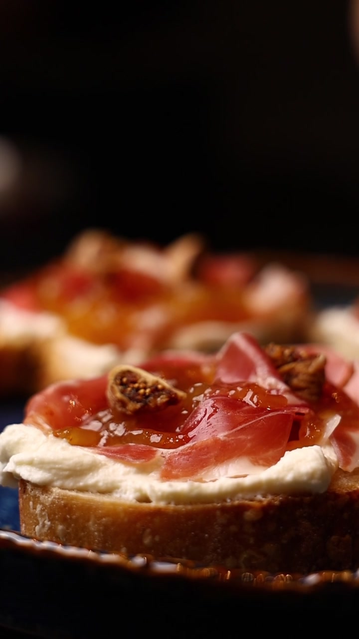 Chef che Guarnisce Bruschetta Gourmet con Fico Fresco