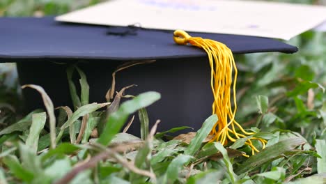 graduation cap and diploma on the grass