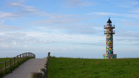 colorful path leading to ajo lighthouse adorned with geometric art on a sunny day in cantabria