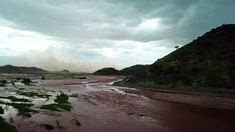 Turistas-En-El-Lago-Natron-Durante-Un-Día-Nublado-En-Tanzania---Toma-Aérea-De-Drones