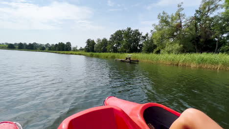 Person,-Die-Ein-Tretboot-Fährt,-Das-Auf-Einem-Ruhigen-Fluss-Unterwegs-Ist