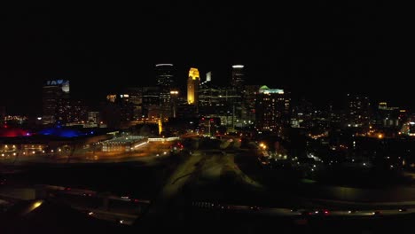 Imágenes-Aéreas-Del-Centro-De-Minneapolis-Por-La-Noche,-Tráfico-Cruzando-Por