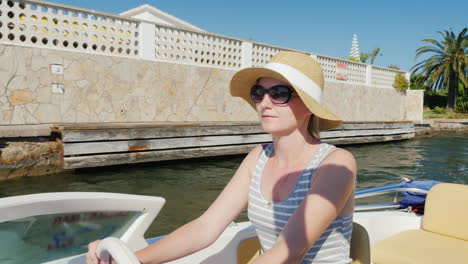 young woman enjoying a holiday resort in europe floating on a boat on the channel empuriabrava spain