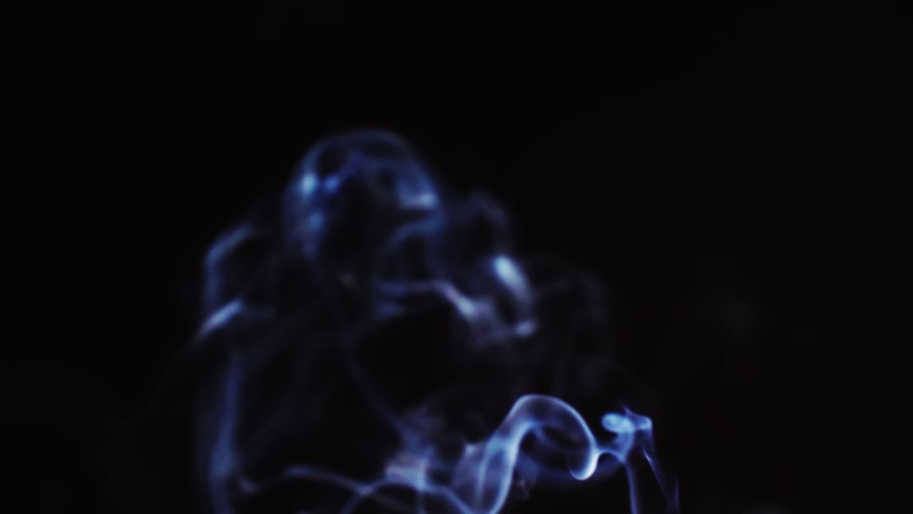 슬로우 모션으로 검정색 배경을 가진 추상 파란색 연기