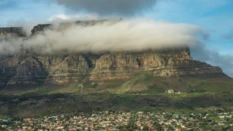 table mountain shrouded in clouds over cape town city in south africa. - timelapse shot