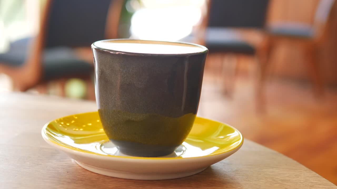 Dark Mug of Coffee on a Yellow Saucer