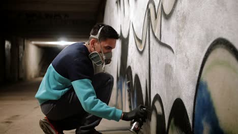 graffiti artist painting on the wall in subway