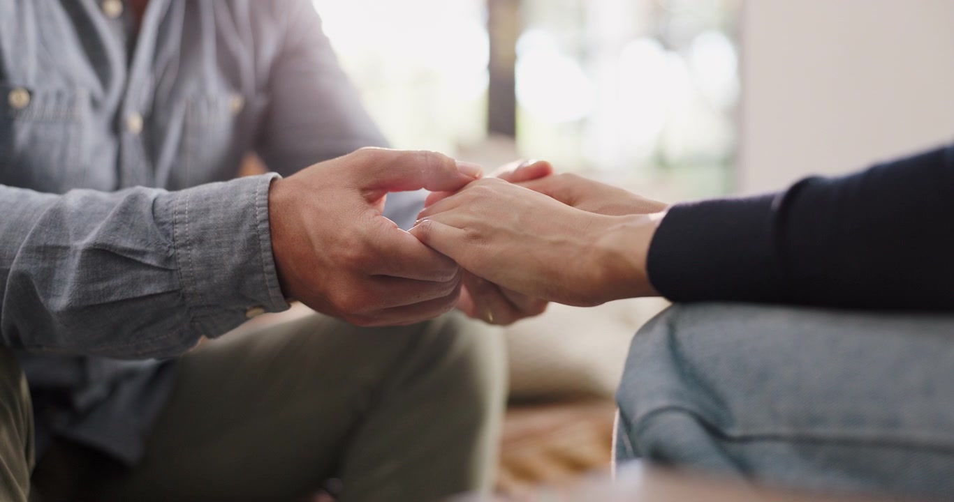 Primo piano di una coppia che si tiene per mano in cerca di conforto e sostegno