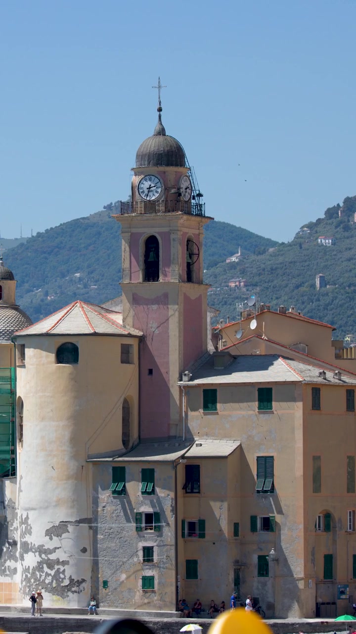 Una panoramica orizzontale fluida attraverso la vivace architettura della Riviera Italiana e una storica basilica sul mare
