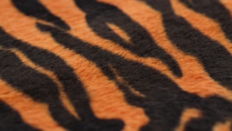 tiger fur fabric close-up. animal print background, striped wool textile. symbol of year 2022. handmade, fashion design and tailoring concept