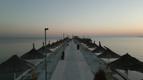 Silhouette-couple-push-stroller-on-public-jetty-on-Adriatic-in-Albania