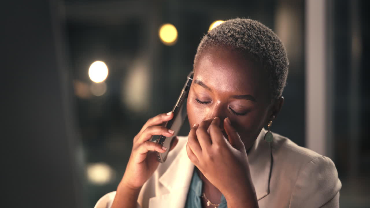 Giovane donna d'affari stressata che parla al telefono in ufficio di notte