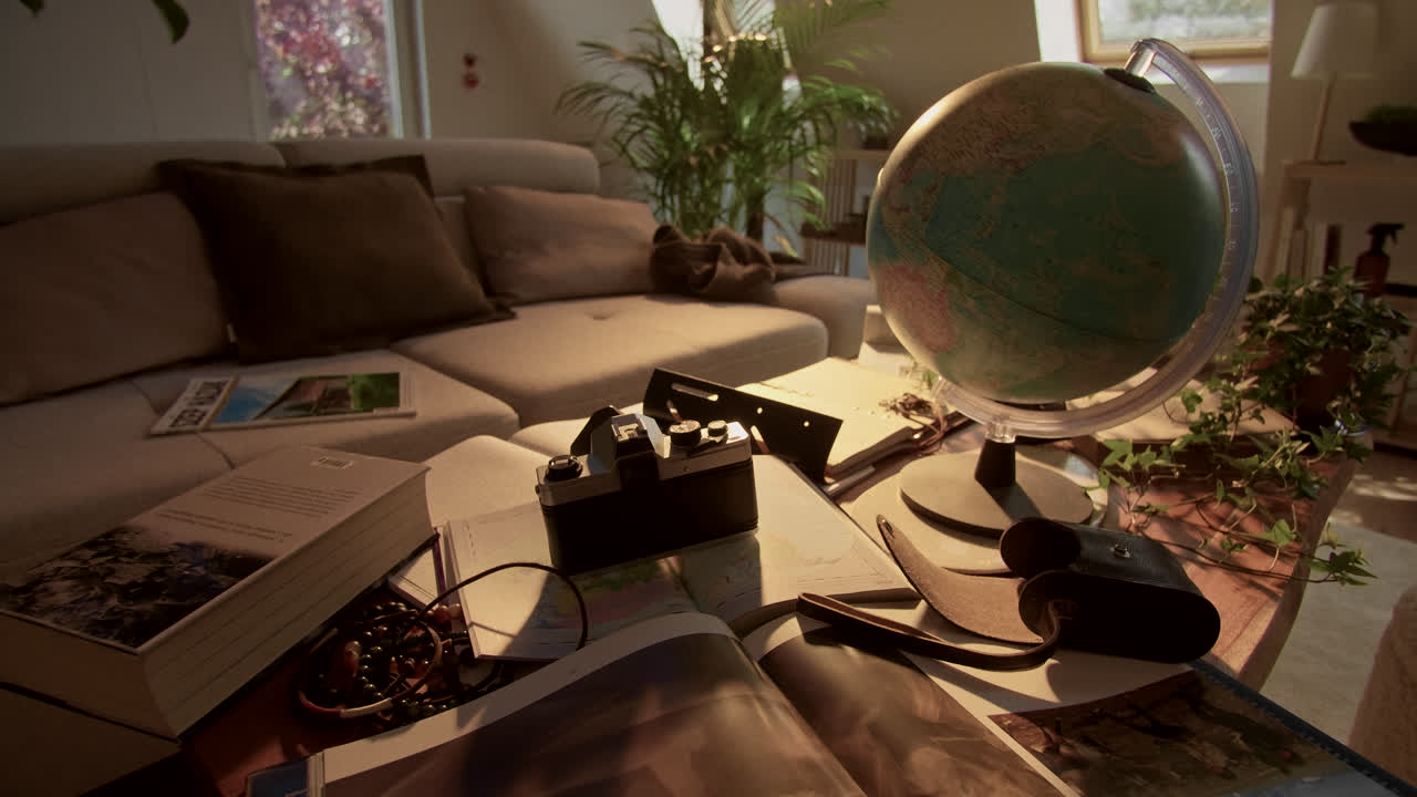 Travel Planning Scene with Globe, Vintage Camera, and Books on Coffee Table