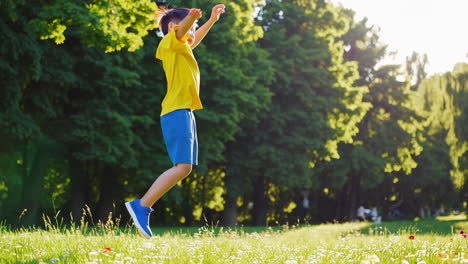 happy young boy playing and jumping in a sunny park