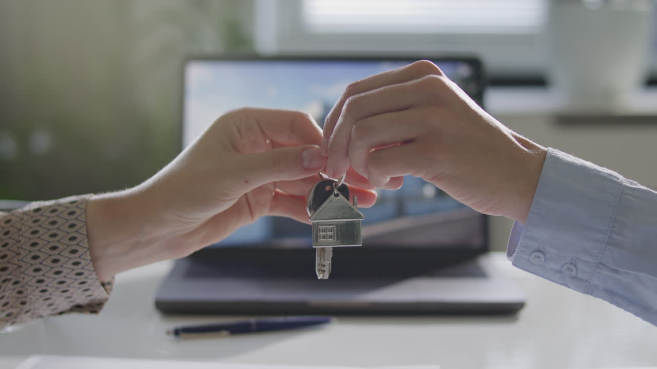 Seller Passing Keys to Client during Real Estate Agreement in Office