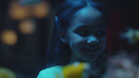 curious-girl-looking-at-fish-in-aquarium-child-watching-colorful-sea-life-swimming-in-tank-learning-about-marine-animals-in-underwater-ecosystem-inquisitive-kid-at-oceanarium