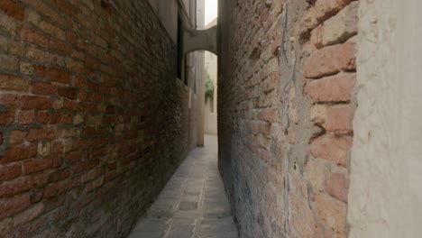 estrecho callejón veneciano entre paredes de ladrillo