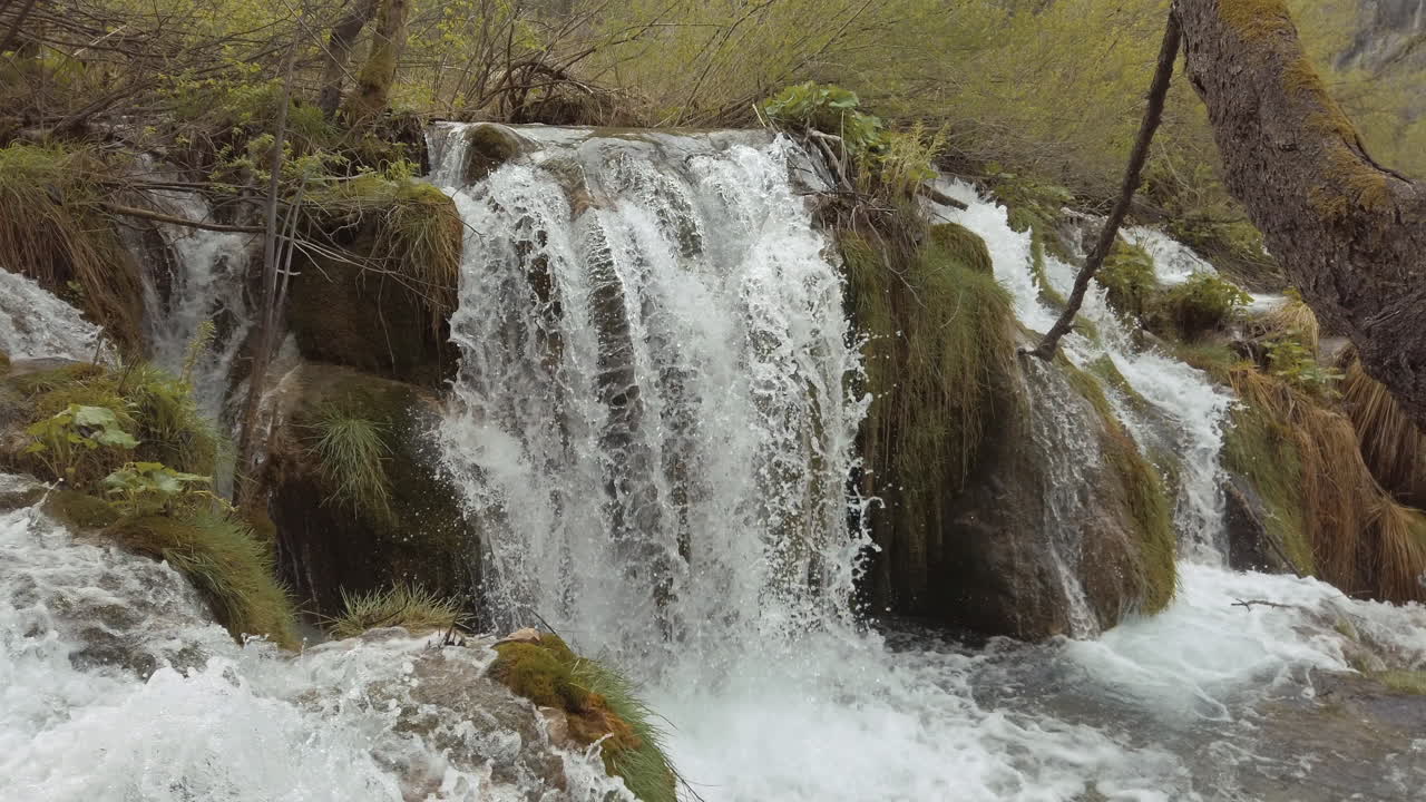Hırvatistan'daki Plitvice Milli Parkı'nda dağ yamacının kenarlarından hızla akan şelaleler dökülüyor