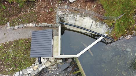 intake dam of small hydroelectric powerplant named markaani in vaksdal norway - top down aerial view showing dam and piping securing the minimum river flow - electricity production norway