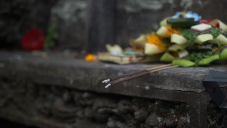 Una-Imagen-Que-Muestra-Ofrendas-Tradicionales-Que-Incluyen-Comida,-Flores-Y-Varitas-De-Incienso-Encendidas,-Posiblemente-Como-Parte-De-Una-Ceremonia-Cultural-O-Religiosa