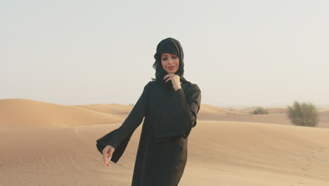 Portrait-Of-Al-Muslim-Woman-In-Hijab-Smiling-At-Camera-In-A-Windy-Desert