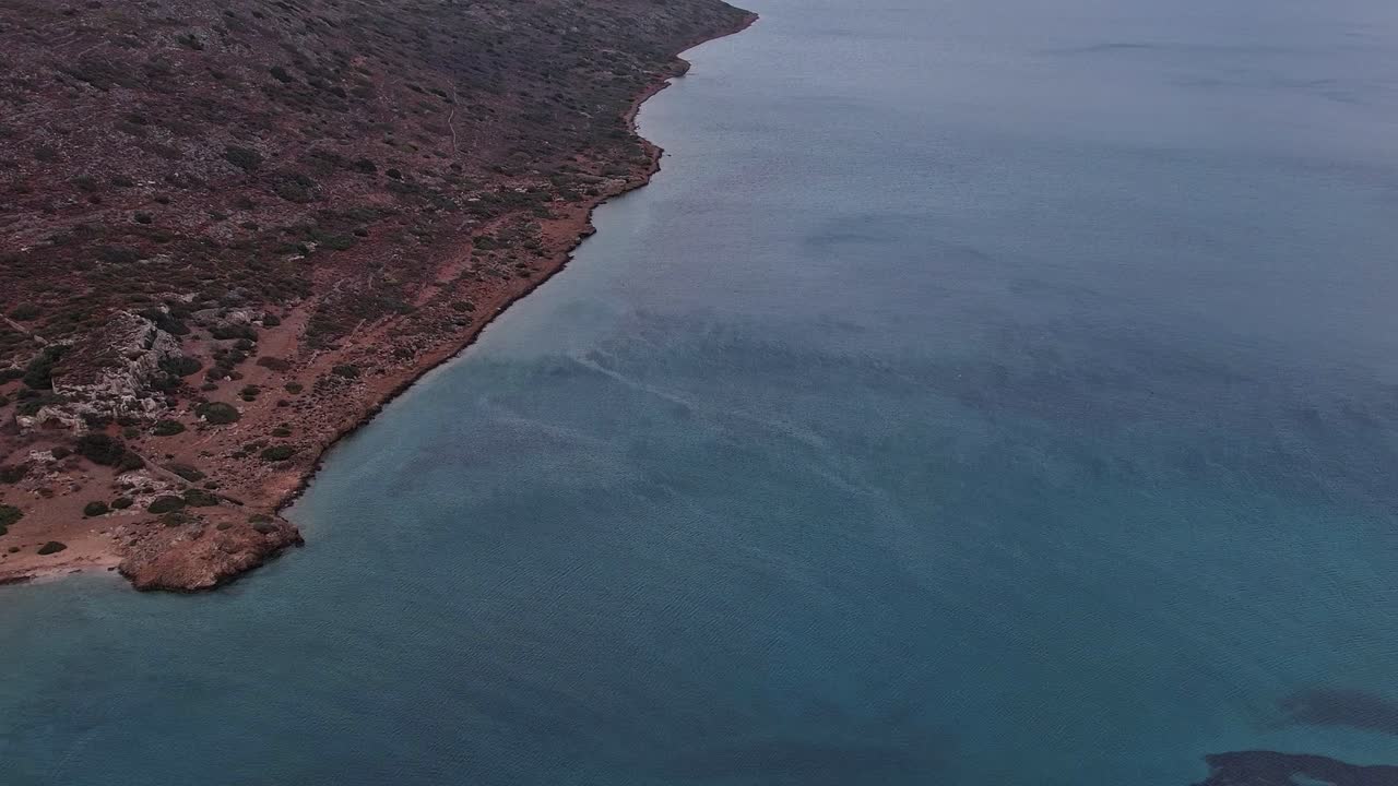 Aerial View of Rocky Coastline and Clear Blue Ocean Water