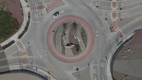 top-down drone shot gazes at a roundabout, slowly rotating clockwise