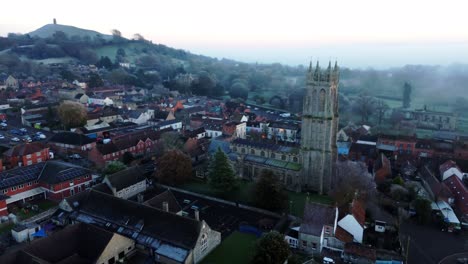 aerial shot of church with glastonbury tor in background