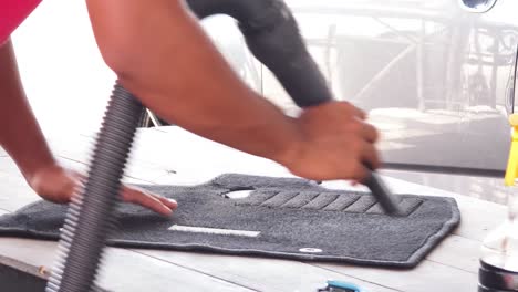 cleaning a car floor mat with a vacuum