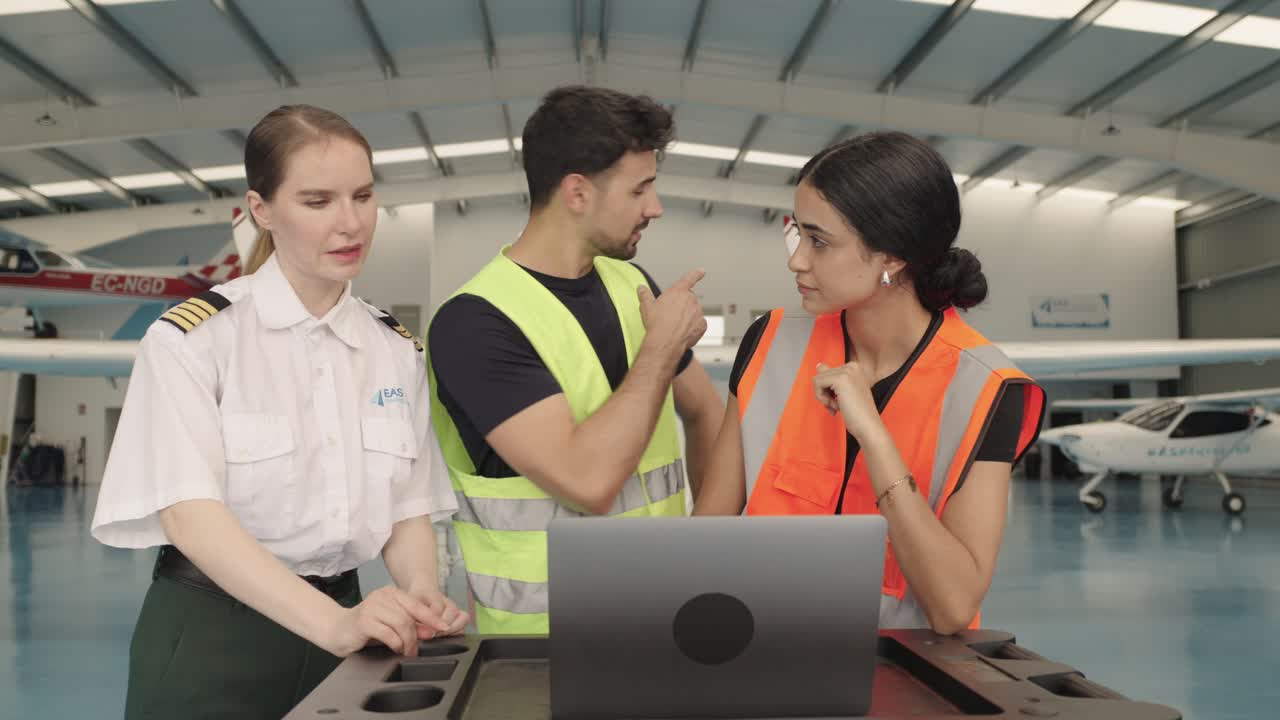 Aircraft mechanics and technicians discussing maintenance in an airplane hangar