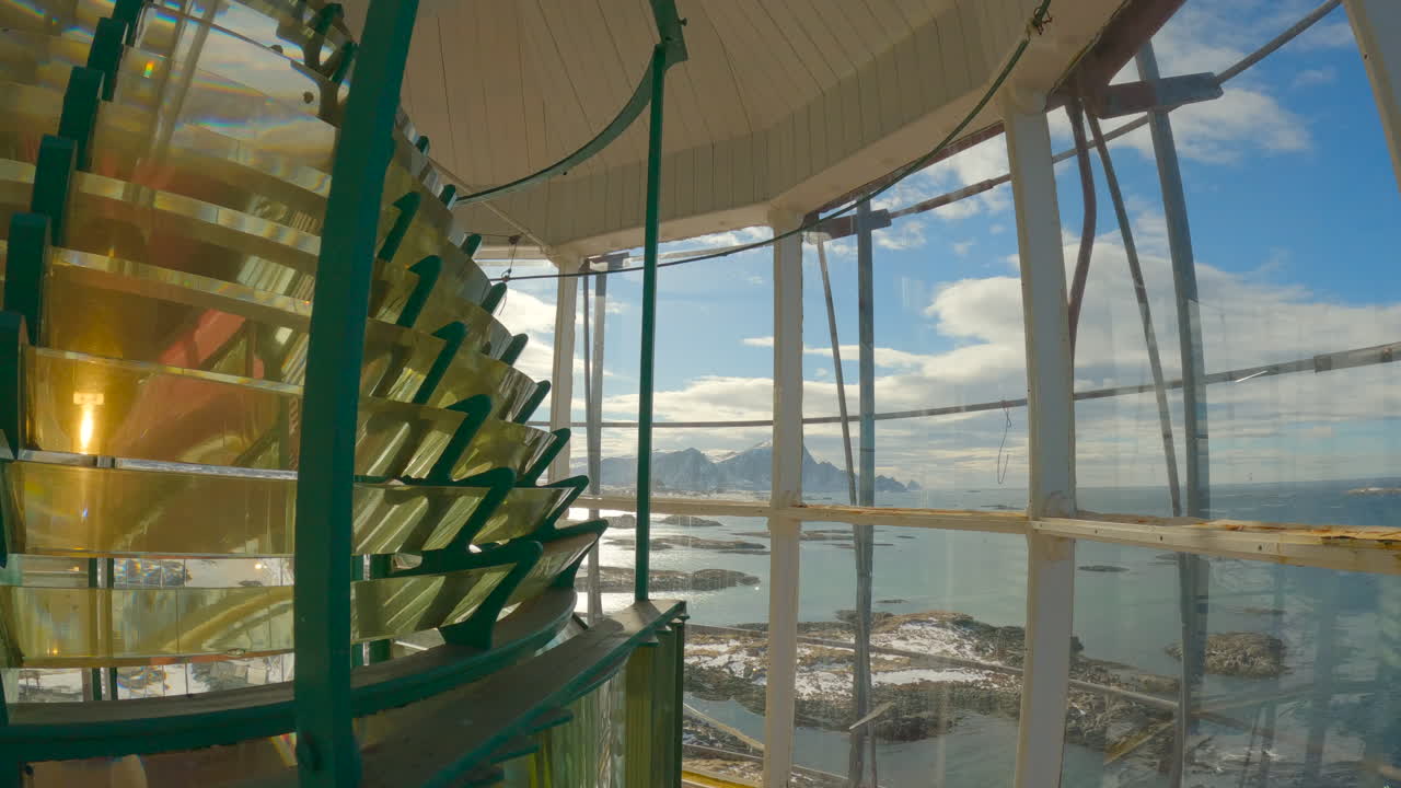 아름다운 항구와 먼 산들을 내다보는 렌즈가 회전하는 안데네 등대 랜턴 룸 내부의 정적 샷