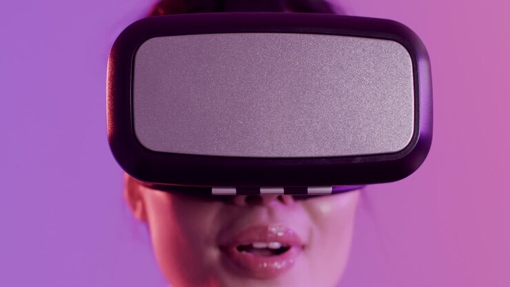 Primo piano di donna asiatica felice che usa un visore VR su sfondo viola, al rallentatore.