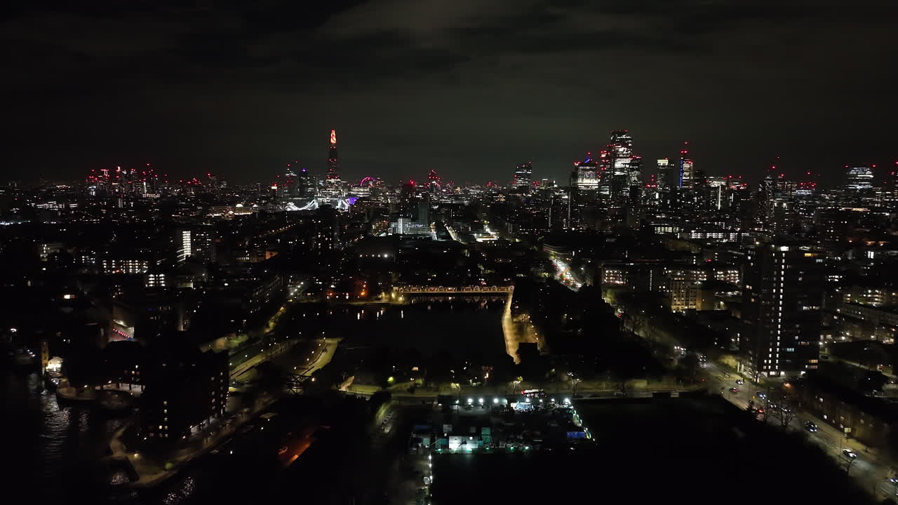 Aerial tilt shot rotating in front of the Shadwell basin, night in London, UK
