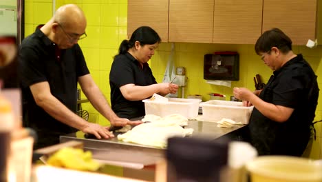 chefs collaboratively preparing traditional chinese dishes