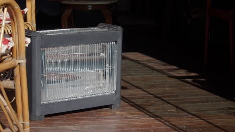 a black electric heater on a wooden porch or patio