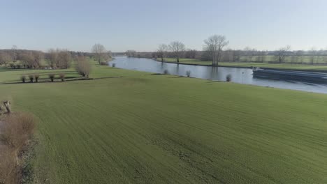 Backwards-going-drone-shot-of-fields-and-rivers