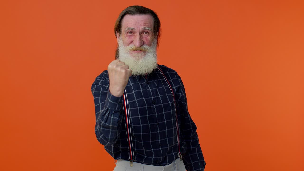 abuelo maduro levantando los puños en gesto lo hice, celebrando el éxito, ganando logro de la meta