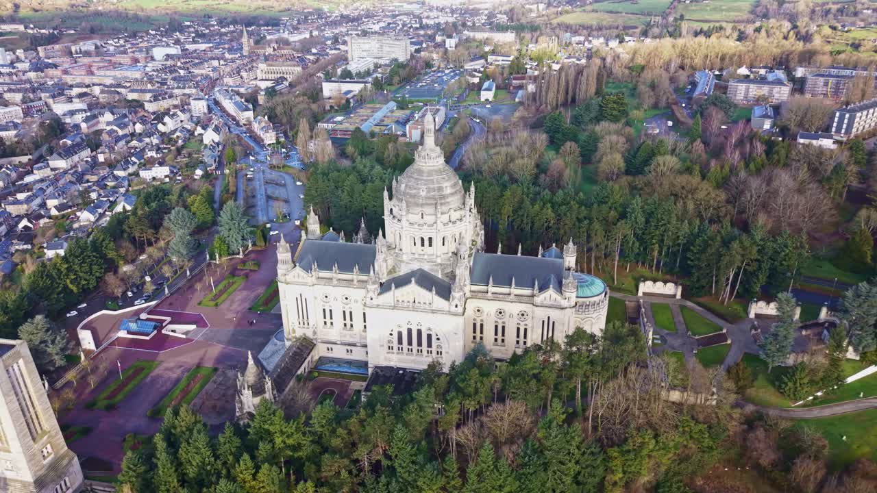 Aerial view of the Basilique Sainte Thérèse in Lisieux city, Calvados county, Normandy region, showing the monumental sanctuary surrounded by wooded park, pilgrimage gardens and historic district