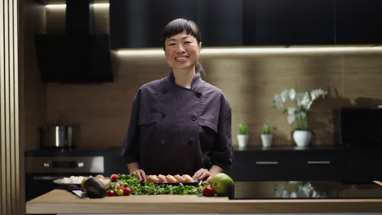 Asian woman chef preparing sushi in a modern kitchen