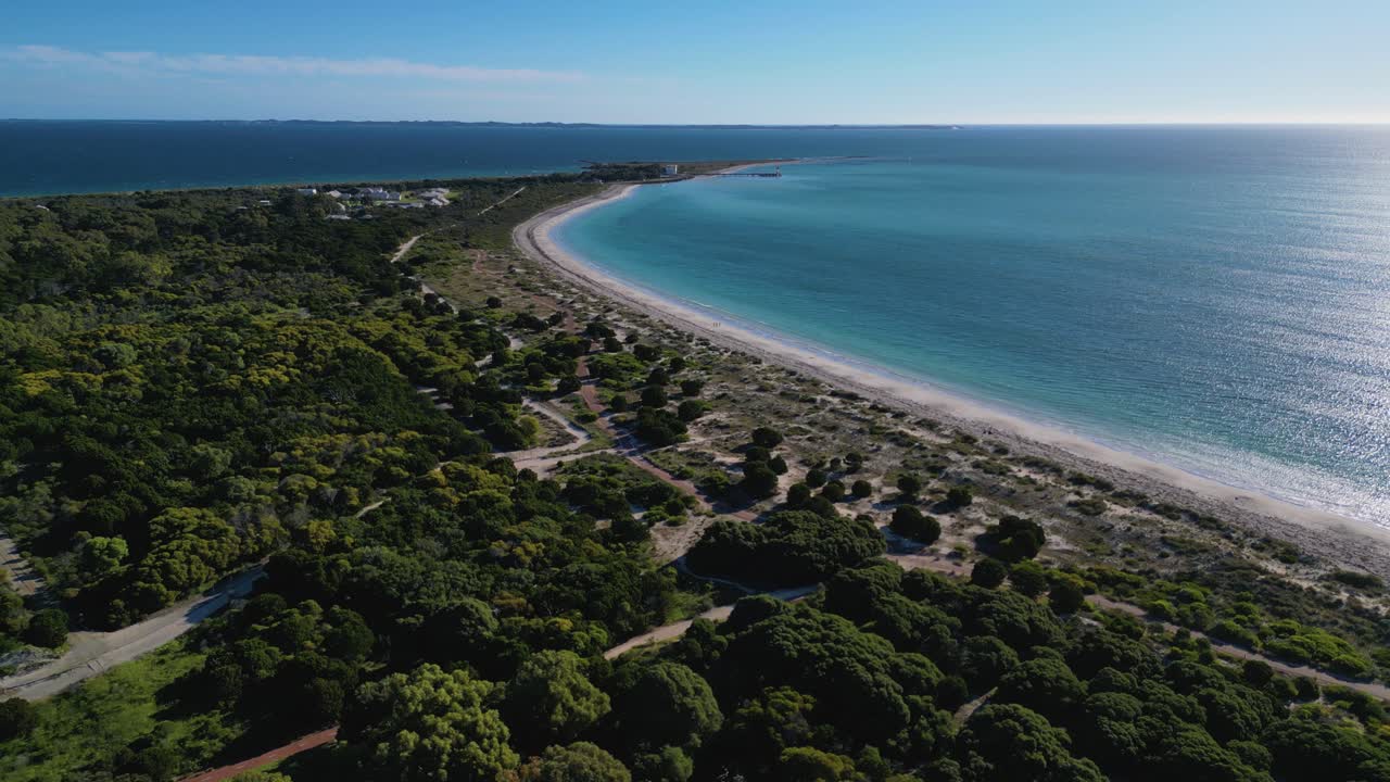 Aerial drone forward moving shot over green vegetation along Coogee Beach Jetty in Perth, Western Australia during evening time