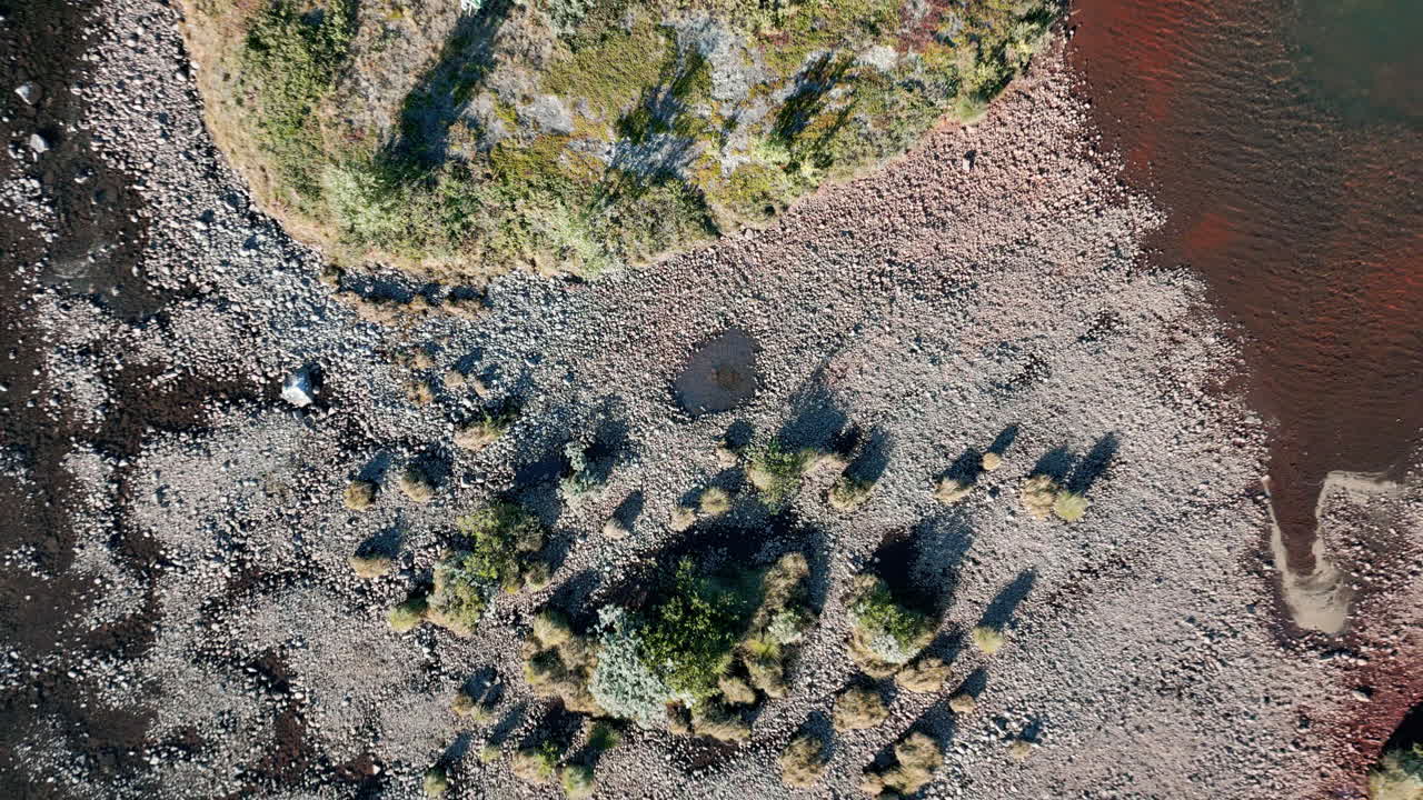 расширение и вращение аэрофотоснимка показывает величественное природное озеро, низкую растительность на берегах озера, бирюзово-голубую воду, нетронутую концепцию природы