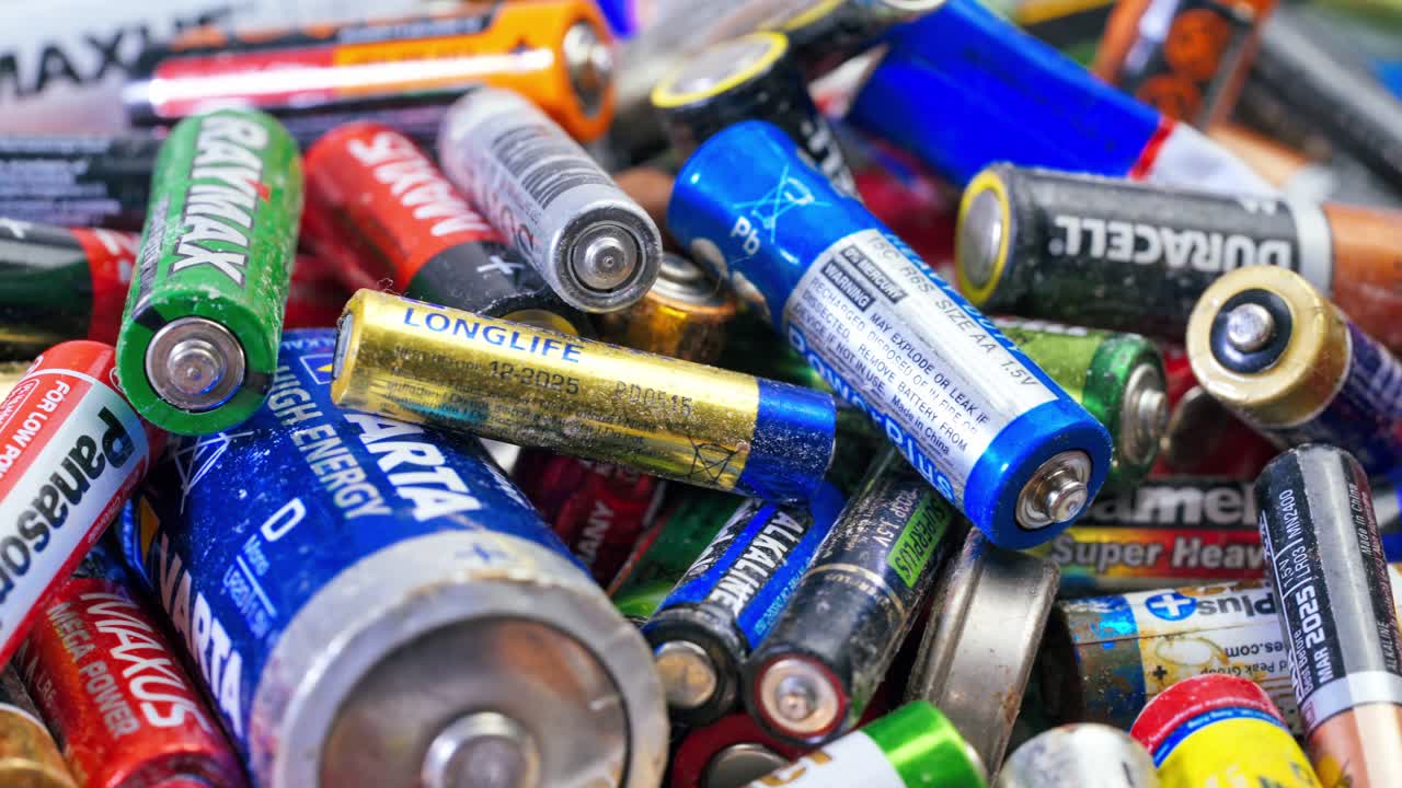 Used batteries from different manufacturers, waste, collection and recycling, high danger for the environment. Batteries background