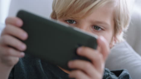 Fröhlicher-Kleiner-Junge,-Der-Sein-Smartphone-Benutzt-Und-Ein-Spiel-Spielt,-Das-Sich-Zu-Hause-Auf-Dem-Sofa-Entspannt.-Kind,-Das-Online-Mit-Mobiltelefontechnologie-Surft,-Anti-Social-Sucht-Konzept,-4K-Videos