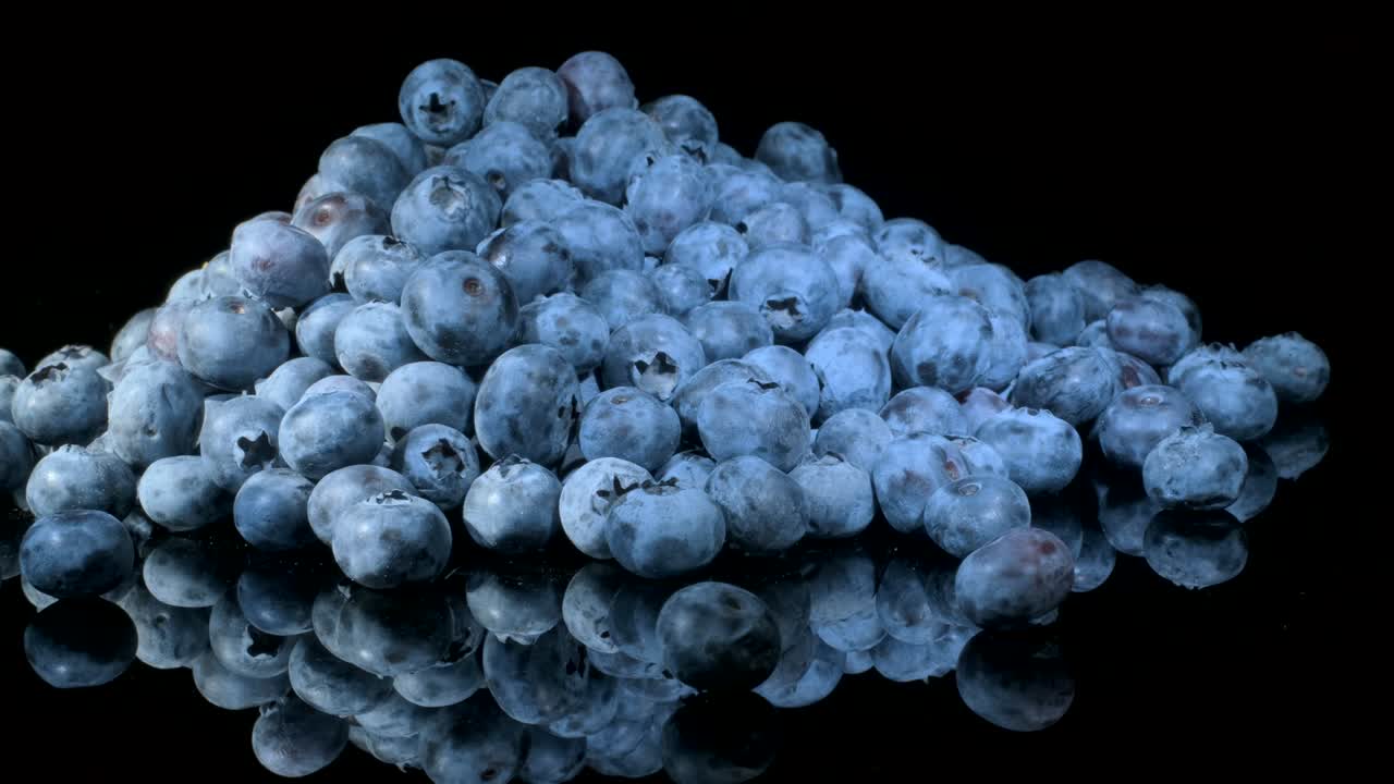 검은 유리판에 블루베리를 회전시켜 반사시. 클로즈업, 카메라 회전 360도. 보그 빌베리, 보그 블루베리, 노던 빌베리 또는 웨스턴 블루버리 (vaccinium uliginosum)