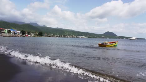 beach view, showing small vessel anchoring in the dominican republic. yellow and green side of the boat
