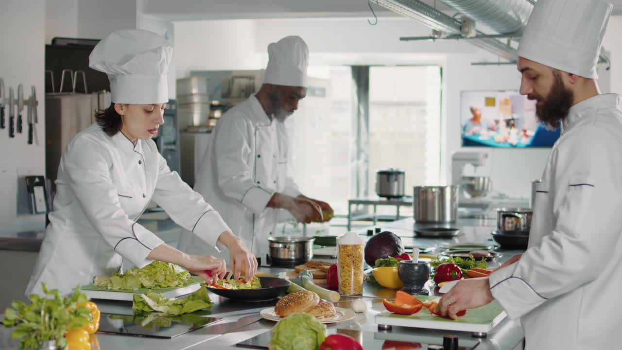 Team of cooks slicing vegetables on cutting board