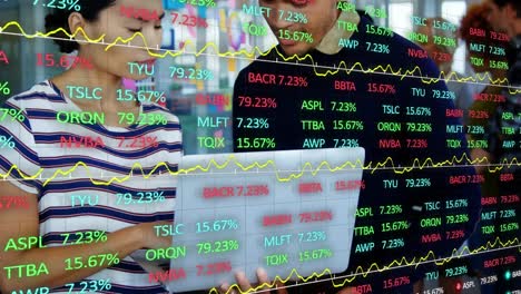 animation of trading board over asian coworkers analyzing report over laptop in office